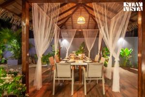 カルジャットにあるStayVista's The Isabella House - Hill-View Villa with Outdoor Pool & Pool-Side Gazeboのテーブルと椅子のあるダイニングルーム