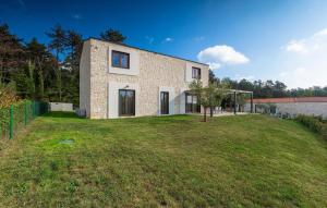 een stenen huis met een tuin ervoor bij Villa-Veritas in Višnjan