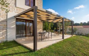 een overdekte patio met een tafel en stoelen bij Villa-Veritas in Višnjan