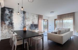 een woonkamer met een tafel en een bank bij Villa-Veritas in Višnjan