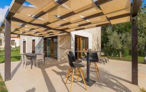 een terras met tafels en stoelen onder een houten pergola bij Villa-Veritas in Višnjan +48 foto's