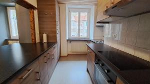 a kitchen with a black counter top and a window at Appartement de vacances Les Jardins in Saint-Imier