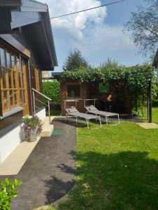 eine Terrasse mit zwei weißen Stühlen im Hof in der Unterkunft Ferienhaus Kumpitsch in Sankt Johann im Saggautal