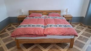 a bed with red and white blankets and pillows at Appartement de vacances Les Jardins in Saint-Imier