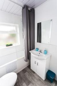 a white bathroom with a sink and a mirror at Probert- Perfectly Placed- Driveway - 3 bed in Wolverhampton