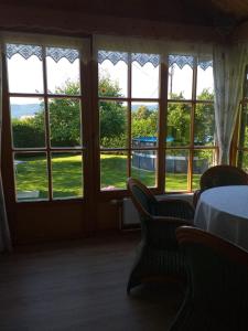 Zimmer mit Fenstern, einem Tisch und Stühlen in der Unterkunft Ferienhaus Kumpitsch in Sankt Johann im Saggautal
