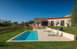 a swimming pool with lounge chairs and a house at Villa-Vesta in Višnjan