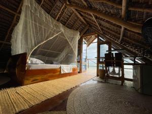 a bedroom with a bed in a thatched roof at Adventurevilla in Kendwa