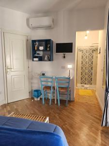 Zimmer mit 2 Stühlen, einem Tisch und einem TV in der Unterkunft il faro di serapide in Neapel