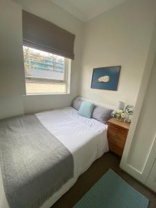 um quarto com uma cama grande e uma janela em Single Bedroom in Chelsea em Londres