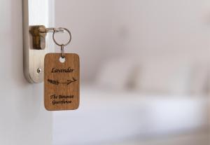 a wooden key tag hanging on a door at The Botanist Guesthouse in Skopelos Town