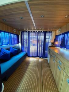 una sala de estar con un sofá azul en un barco en Yate Gijón, experiencia única N, en Gijón