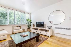 een woonkamer met een salontafel en een spiegel bij Coolullah Charm - Your Cosy South Yarra Stay in Melbourne
