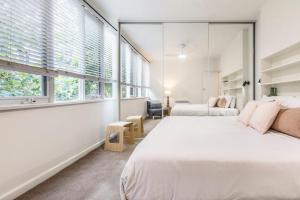 een slaapkamer met 2 bedden en 2 ramen bij Coolullah Charm - Your Cosy South Yarra Stay in Melbourne