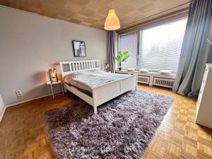 a bedroom with a white bed and a rug at Exklusiver Rheinblick fussläufig zur Messe! in Düsseldorf