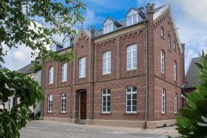 a large red brick building with white windows at Römer-Apartment in Xanten