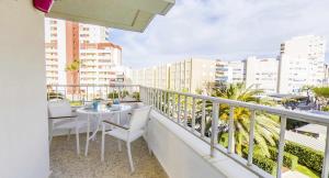a balcony with a table and chairs and buildings at Apartamento gandiaziar premium in Gandía