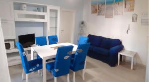 a dining room with a table and blue chairs at I Velieri in Cesenatico