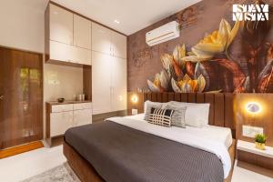 カルジャットにあるStayVista's The Isabella House - Hill-View Villa with Outdoor Pool & Pool-Side Gazeboの壁に絵が飾られた大きなベッドのある寝室 +23枚の写真