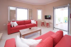 a living room with a red couch and a table at Kazarma Luxury Apartment at Klismata village 8 guests in Spartià