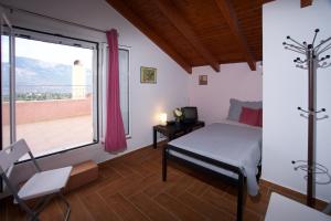 a bedroom with a bed and a large window at Kazarma Luxury Apartment at Klismata village 8 guests in Spartià