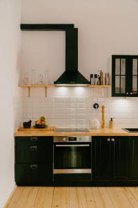 a kitchen with black cabinets and a stove at 4ry pokoje in Cieszyn