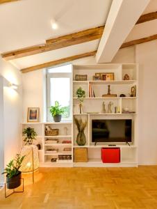 a living room with white shelves and a flat screen tv at Dreamy Sunset Loft in Sofia City Center in Sofia