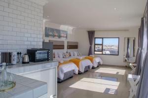 a hotel room with two beds and a kitchen at Shark Island Guesthouse in Lüderitz