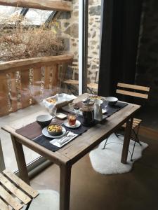 - une table en bois avec de la nourriture sur le balcon dans l'établissement Suites de Campagne Les Eydieux, à Saint-Angel