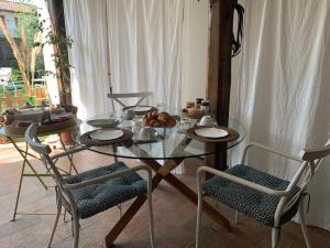 uma mesa de vidro com cadeiras e comida em B&B Karin - Rooms & Breakfast em Udine