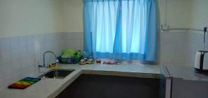 uma cozinha com um lavatório e uma cortina azul em PD Corus myHoliday Homes & Apartments em Port Dickson