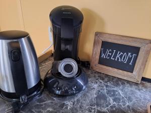 a coffee maker sitting on a counter next to a sign at Vakantie bij 17 in Serooskerke