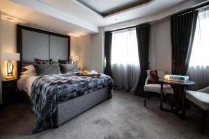 ロイヤル・タンブリッジ・ウェルズにあるOne Warwick Park Hotelのベッドルーム1室(ベッド1台、椅子、窓付)