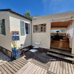 a house with two chairs and a porch with a deck at MOBILE HOME COSY 4/5 personnes in Hyères