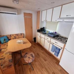 a small kitchen with a table and a counter top at MOBILE HOME COSY 4/5 personnes in Hyères