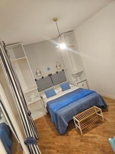 Schlafzimmer mit einem Bett mit blauer Bettwäsche und blauen Kissen in der Unterkunft il faro di serapide in Neapel