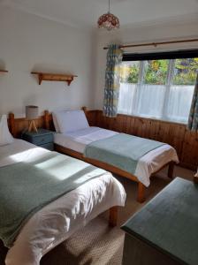 1 dormitorio con 2 camas y ventana en River Edge Lodges, en Bridge of Earn