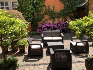 een patio met stoelen en tafels en paarse bloemen bij Metropolitan Boutique Hotel in Krakau