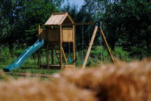 einen Holzspielplatz mit Rutsche auf dem Feld in der Unterkunft Prullenbos Tiny Nutz Nest in Wetteren