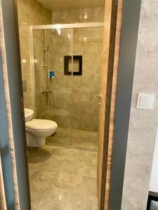 a bathroom with a toilet and a glass shower at M-ODA OTEL in Antalya