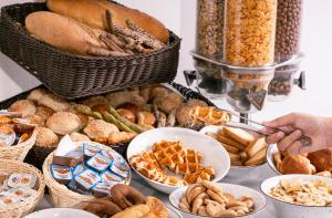 a table full of different types of bread and pastries at Athens Cypria Hotel in Athens