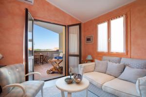 een woonkamer met een bank en een tafel bij Casa delle Mimose by Wonderful Italy in Badesi