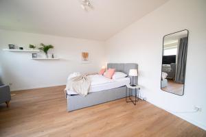 um quarto branco com uma cama e um espelho em Apartment - Central with kitchen - Balcony - Fair em Neuss