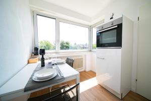 uma cozinha com uma grande janela e um frigorífico branco em Apartment - Central with kitchen - Balcony - Fair em Neuss