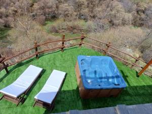two chairs and a hot tub on a lawn at Casa Rural Cortijo Molino Altero in Trevélez