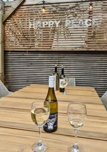 eine Flasche Wein und zwei Gläser auf dem Tisch in der Unterkunft Happy Place, Sheringham Stunner - Crabpot Cottages Sheringham in Sheringham