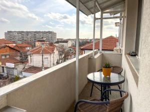 a balcony with a table and chairs and a view at Апартамент за гости Бажолета - светъл и уютен дом в сърцето на Ямбол in Yambol