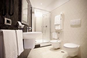 ein Bad mit einem Waschbecken, einem WC und einer Dusche in der Unterkunft AP 2bd Mayfair in London