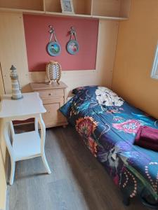 a small bedroom with a bed and a table at Vakantie bij 17 in Serooskerke