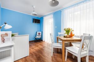 comedor con paredes azules, mesa y sillas en Oliwia, en Jastrzębia Góra